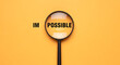 © creative - Magnifier focuses on the possible side of the word impossible.