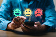 © Sutthiphong - Customer satisfaction feedback concept showing person using mobile phone to select emotion face rating with happy, neutral, sad smiley icons representing service review and user experience evaluation