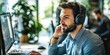 © Creations Photo  - A man in a call center, wearing a headset and working on a computer.