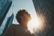 © Amena - Man gazing upward at a tall building during the day with sunlight reflecting off the glass facade creating a striking urban atmosphere
