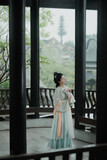 Woman in traditional attire standing in a serene setting Chinese word means tranquility.