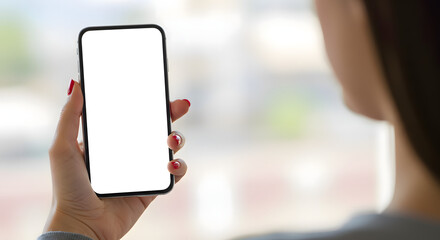 Rear view of woman holding smartphone with blank white screen, mockup for app design or website presentation.
