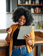 © Lumos sp - Happy young afro american woman having fun preparing food and looking for recipes online using a tablet in kitchen, or a young businesswoman working from home office making connections online
