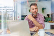 © Westend61 - Confident professional in modern office working on laptop with coffee