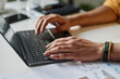 © TrueFrame Collective - Closeup of hands of unrecognizable man typing on laptop at work in office, copy space