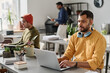© TrueFrame Collective - Selective focus shot of three diverse Indian men working in modern office, copy space