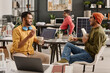 © TrueFrame Collective - Young Indian men wearing casual clothes sitting at desk in modern office, having lunch and chatting