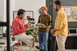 © TrueFrame Collective - Medium long shot of group of three Indian men coworking on new project in IT company office