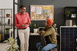 © TrueFrame Collective - Cheerful mature and young Indian specialists wearing casual clothes standing and sitting in modern office having conversation