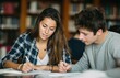 © yevgeniya131988 - Students studying together in the library, writing notes