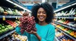 © Meow Creations - Joyful african american woman holding fresh red grapes in a supermarket