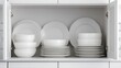 © Lonely Dragon - A neatly organized kitchen cabinet displaying an array of white dinnerware, including bowls and plates, emphasizing simplicity and elegance.