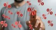© Generative AI - Conceptual Digital Display of Red Percentage Symbols Floating Around a Man's Hand, Representing Sales and Discounts