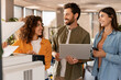 © Maria Vitkovska - Business team printing and discussing documents in office using photocopier and laptop
