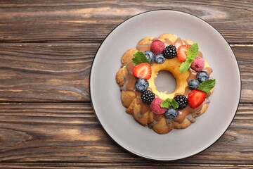 Wall Mural - tasty bundt cake with berries, chocolate and mint on wooden table, top view. space for text
