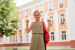 © sementsova321 - A cheerful young girl with a red backpack raises her fists in excitement, ready for the first day of school.