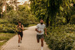 © La Famiglia - Couple running in a green park promoting healthy lifestyle and wellness