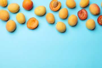 Wall Mural - many fresh apricots on light blue background, flat lay. space for text