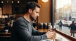© MST - Man using smartphone in a cafe enjoying a coffee