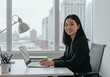 © MdMashud - Young asian woman working on a laptop in a modern office