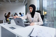 © Oleksii Syrotkin/Stocksy - Data analyst in hijab closing laptop in end of working day at office