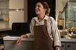 © Milles Team/Stocksy - Young woman working as barista at cafe smiling and looking away
