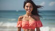 © demzp - A smiling woman enjoys a beautiful day at the beach in a peach top