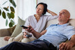 © Jovo Jovanovic/Stocksy - Couple relaxing on couch, watching TV with remote.