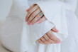 © Liliya Rodnikova/Stocksy - Closeup hands with emerald ring and pink manicure