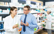 © JackF - Girl pharmacist gives advice to a man what medicinal ointment to buy