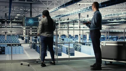 Data center software developers monitor deep learning processes, reviewing operational metrics. Server farm IT specialists work together to review neural networks reports during inspection, camera A