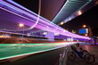The highway car rainbow light trails of modern city buildings