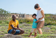 © Anna Fedorova/Stocksy - Family portrait with smiling father and Child hugs his pregnant mother