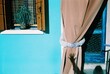© Anna Malgina/Stocksy - shadow hand on a Colorful houses in Venice
