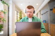 © Santi Nuñez/Stocksy - Focused office employee working on laptop with headphones