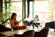 © Boris Jovanovic/Stocksy - Guests sitting in the hotel lobby.