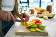 © Marko Geber - Close up of a woman chopping fresh vegetables on modern kitchen counter