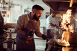 © Davor - Tattooed chef preparing food in restaurant kitchen