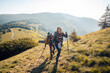 © Davor - Couple hiking up a mountain hill with trekking poles on sunny day