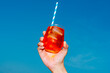 © Juan Moyano/Stocksy - man holds a glass of spritz under a clear blue sky