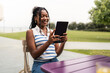 © Alvaro Lavin/Stocksy - Young black student using tablet in university campus park