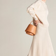 © Ulas&Merve/Stocksy - Minimalist Beige Outfit with Stylish Tan Handbag and Soft Aesthe