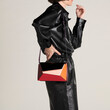 © Ulas&Merve/Stocksy - Fashionable Black Outfit with a Stylish Colorful Geometric Purse