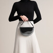 © Ulas&Merve/Stocksy - Stylish Black and White Outfit with a Sophisticated Handbag