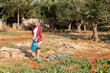 © Anna Fedorova/Stocksy - Woman Waters Vegetable Plants in Garden on a Sunny Afternoon