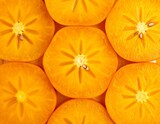 Macro view of persimmon slices showing natural star pattern.