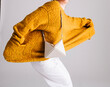 © Ulas&Merve/Stocksy - Yellow Sweater with Stylish Accessory in Modern Minimalist Style