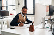 © Elena Kharichkina/Stocksy - Black businessman working on computer