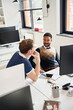 © Elena Kharichkina/Stocksy - Colleagues discussing ideas in modern office setting