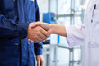 © Sayed GraphicsBD - Two professionals in a factory shaking hands to seal a deal